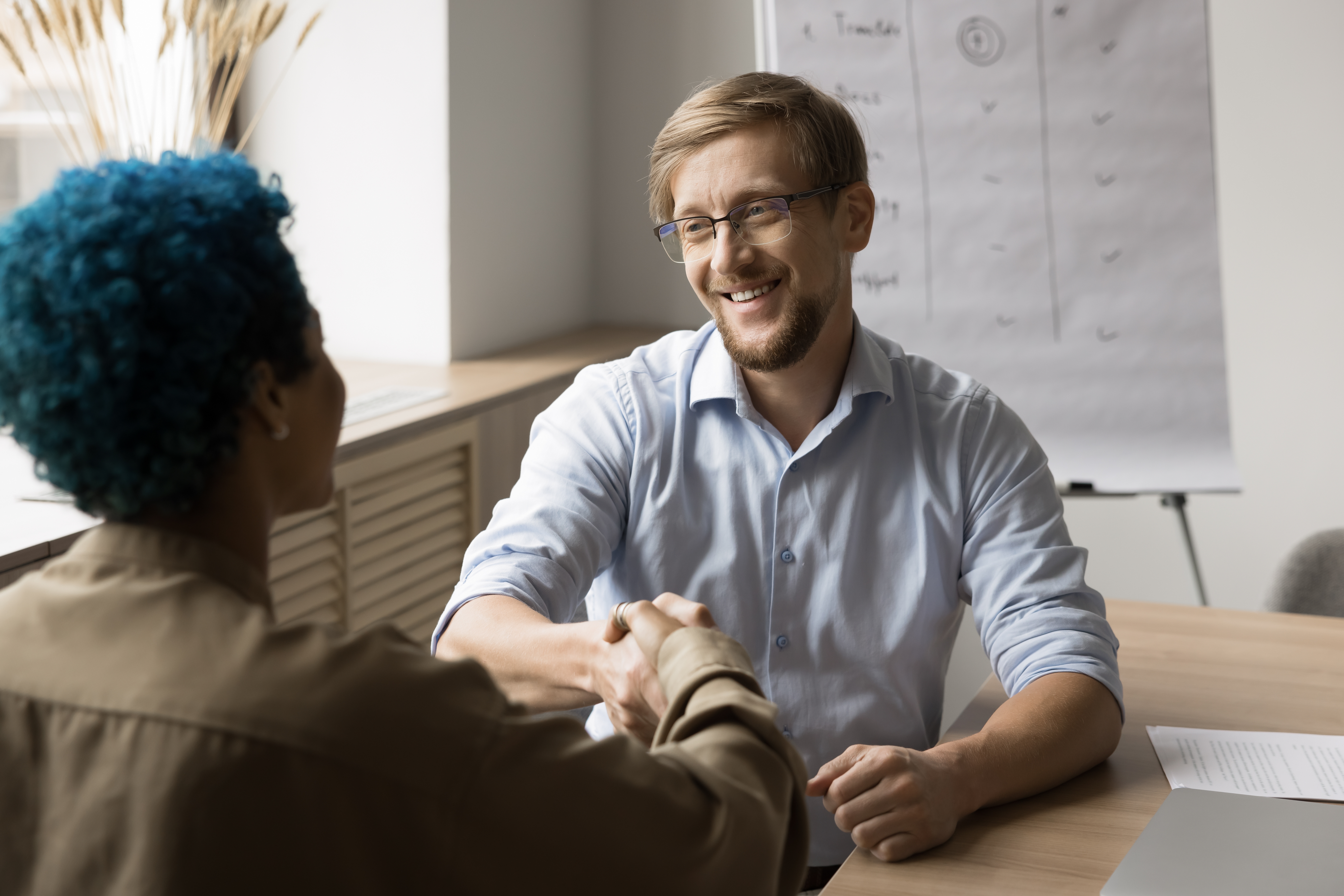 A sales representative shaking hands with a customer during a direct customer engagement.